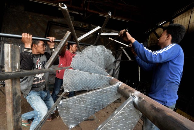 Workers weld pieces of a circular stairway together at a workshop in Jakarta on May 25, 2016. Indonesia has opened a string of new sectors to foreign businesses to attract more investment and help pull Southeast Asia's biggest economy out of a slowdown, an official said. (Photo by Bay Ismoyo/AFP Photo)