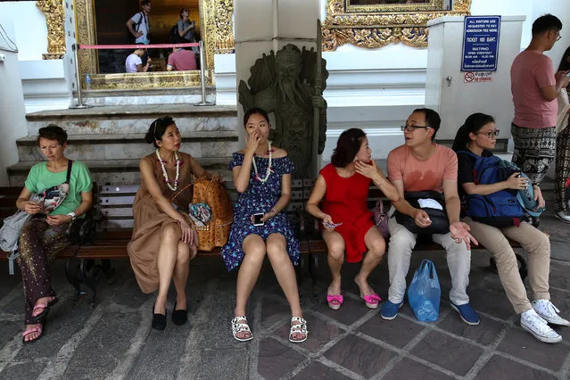 Chinese tourists take a break at Wat Pho in Bangkok, Thailand, October 3, 2016. (Photo by Athit Perawongmetha/Reuters)