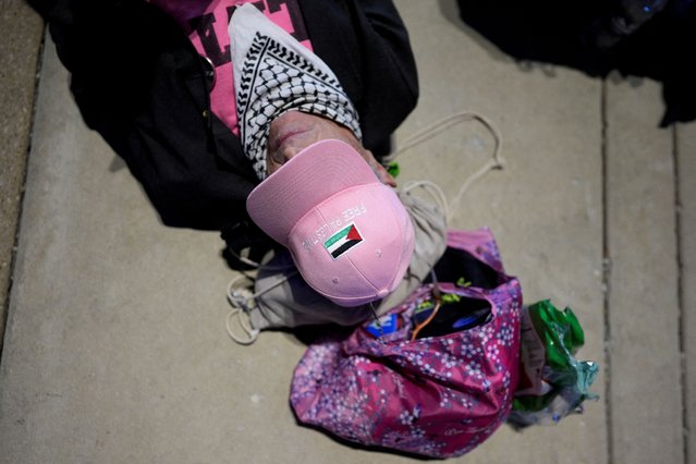 A person lays on the ground as pro-Palestinian protesters stage a protest outside the venue of the Democratic National Convention (DNC) at the United Center, in Chicago on August 22, 2024. (Photo by Cheney Orr/Reuters)