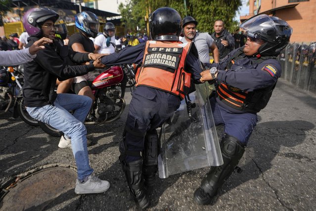 A protester scuffles with police during demonstrations against the official election results declaring President Nicolas Maduro's reelection, the day after the vote in Caracas, Venezuela, Monday, July 29, 2024. (Photo by Matias Delacroix/AP Photo)