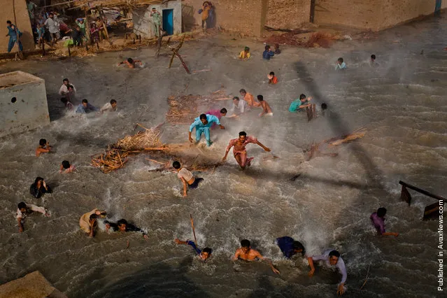 In this photo released by the World Press Photo, the 1st Prize People In The News Stories of the 2011 World Press Photo Contest by Daniel Berehulak, Australia, Getty Images shows flood victims scrambling for food as they battle the downwash from a Pakistan army helicopter during relief operations, in Dadu, Pakistan, Sept. 13, 2010