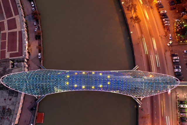 This aerial view taken in Tbilisi on December 16, 2023 shows the Bridge of Peace illuminated with EU flag to mark the Georgia's European Union candidate status. (Photo by Vano Shlamov/AFP Photo)