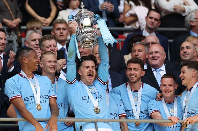 Manchester City's English midfielder Jack Grealish (C) lifts the trophy after the English FA Cup final football match between Manchester City and Manchester United at Wembley stadium, in London, on June 3, 2023. (Photo by Adrian Dennis/AFP Photo)