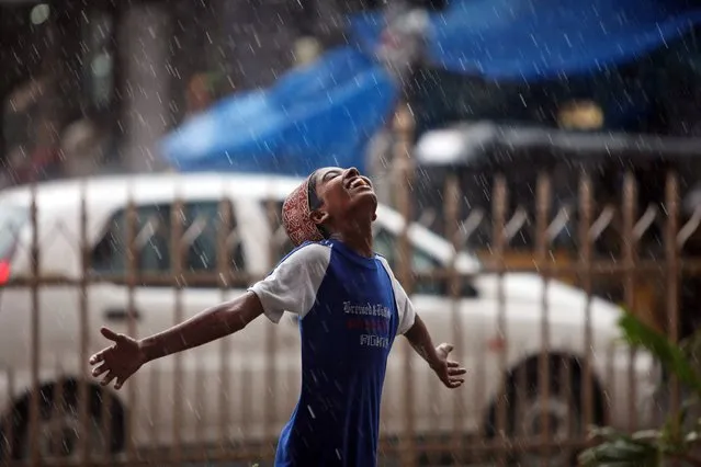 An Indian Muslim boy stretches his arms and looks skyward as rain falls in Hyderabad, India, Tuesday, July 1, 2014. (Photo by Mahesh Kumar A./AP Photo)