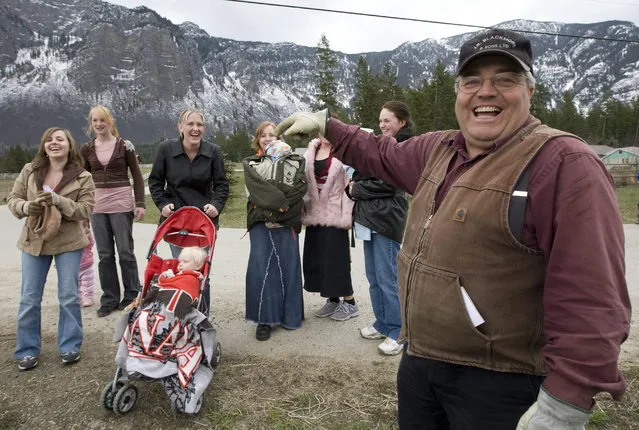 In this April 21, 2008, file photo, Winston Blackmore, the religious leader of the controversial polygamous community of Bountiful located near Creston, British Columbia, Canada, shares a laugh with six of his daughters and some of his grandchildren. Blackmore has been convicted of practicing polygamy after a decades-long legal fight. Blackmore was found guilty Monday, July 24, 2017, by British Columbia Supreme Court Justice Sheri Ann Donegan. (Photo by Jonathan Hayward/The Canadian Press via AP Photo)