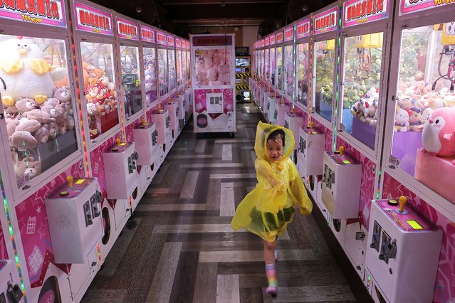 A girl plays in a shop as Typhoon Krathon approaches in Kaohsiung, Taiwan on October 2, 2024. (Photo by Ann Wang/Reuters)