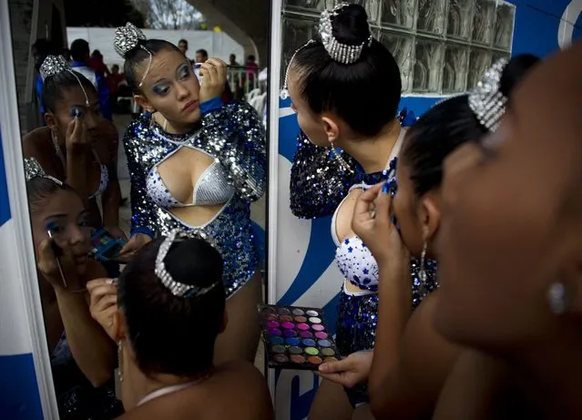 Colombian salsa dancers put on their make up backstage before their presentation during the IX World Salsa Festival at the Cañaveralejo Bullring in Cali on July 27, 2014. (Photo by Luis Robayo/AFP Photo)
