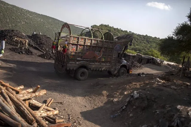 A truck drives past a coal field in Choa Saidan Shah, Punjab province, May 5, 2014. (Photo by Sara Farid/Reuters)