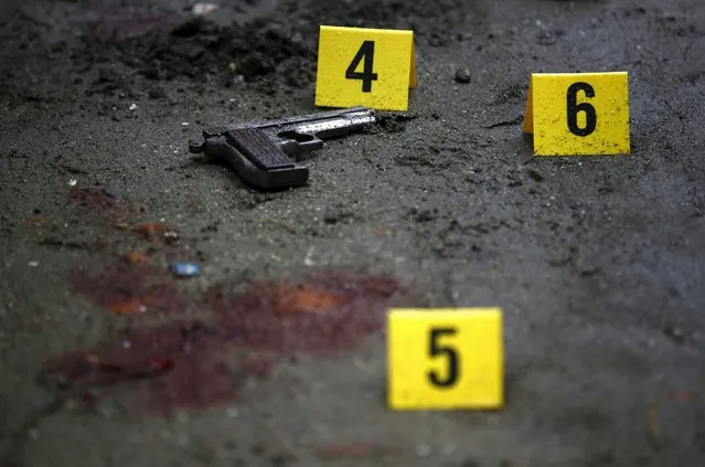 A gun lies near blood stains at the crime scene where Kumar Shrestha, also known as Kumar Ghainte, was shot dead during what local media termed as a police encounter in Kathmandu, Nepal August 20, 2015. According to local media, three police personnel and two of the gangster's friends were also injured in the incident. (Photo by Navesh Chitrakar/Reuters)