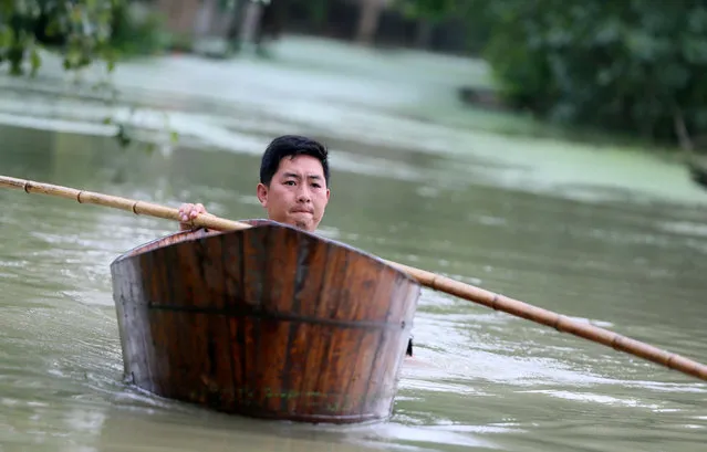 A man rows a wood basin on a flooded street in Hefei, Anhui province, China, July 6, 2016. (Photo by Reuters/Stringer)