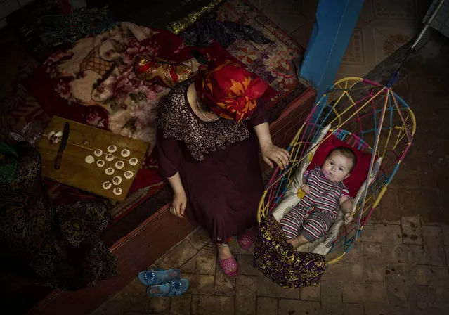 A Uyghur woman takes care of her child at home before the Eid holiday  on July 28, 2014 in old Kashgar, Xinjiang Province, China. (Photo by Kevin Frayer/Getty Images)