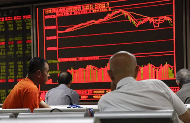 Investors monitor stock data on an electronic board at a securities brokerage house in Beijing, China, 26 August 2015. The benchmark Shanghai Composite Index closed down 1.27 per cent on 26 August despite fresh measures introduced after sharp stock plunges in previous days. The Shenzhen Component Index closed down 2.92 per cent while the ChiNext Index the ChiNext Index, which tracks tech and other growth enterprises, plunged 5.06 per cent. (Photo by Rolex Dela Pena/EPA)