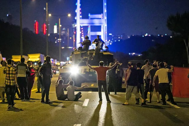 People take over a tank near the Fatih Sultan Mehmet bridge during clashes with military forces in Istanbul on July 16, 2016. Istanbul's bridges across the Bosphorus, the strait separating the European and Asian sides of the city, have been closed to traffic. Turkish military forces on July 16 opened fire on crowds gathered in Istanbul following a coup attempt, causing casualties, an AFP photographer said. The soldiers opened fire on grounds around the first bridge across the Bosphorus dividing Europe and Asia, said the photographer, who saw wounded people being taken to ambulances. (Photo by Gurcan Ozturk/AFP Photo)