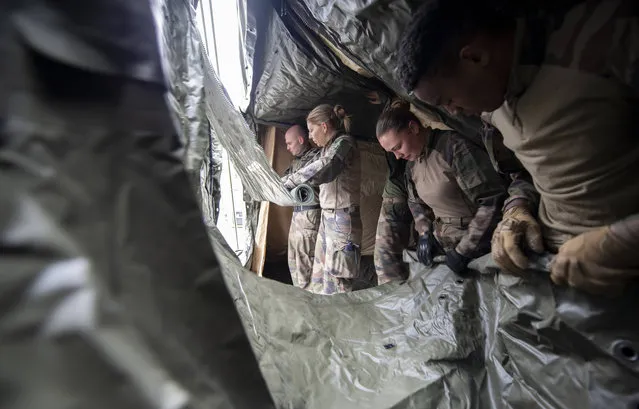 This photo provided by the French Army shows soldiers setting up tents as they start building a military hospital in Mulhouse, eastern France, Saturday March 21, 2020. The make-shift army hospital will house around 30 intensive care beds. For most people, the new coronavirus causes only mild or moderate symptoms. For some it can cause more severe illness. (Photo by Julien Chatelier/DICOD via AP Photo)