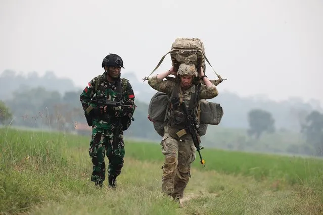 An Indonesian, left, and an U.S. soldier walks together during their annual joint combat exercises in Baturaja, South Sumatra province, Indonesia, Wednesday, August 3, 2022. The United States and Indonesian militaries began their annual joint combat exercises Wednesday on Indonesia's Sumatra island, joined for the first time by partner nations, signaling stronger ties amid growing maritime activity by China in the Indo-Pacific region. (Photo by AP Photo)