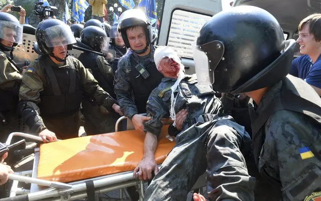 Ukrainian national guard officers carry an injured colleague on a stretcher outside the parliament building in Kiev, Ukraine, August 31, 2015. (Photo by Reuters/Stringer)
