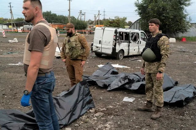 Ukrainian servicemen stand next to the bags containing the bodies of people who died after a Russian attack in Zaporizhzhia, Ukraine, Friday, September 30, 2022. (Photo by Leo Correa/AP Photo)