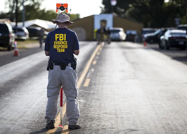 A member of the FBI's Evidence Response Team works on the crime scene of the mass shooting at the First Baptist Church in Sutherland Springs, Texas on Monday, November 6, 2017. (Photo by Nick Wagner/Austin American-Statesman via AP Photo)
