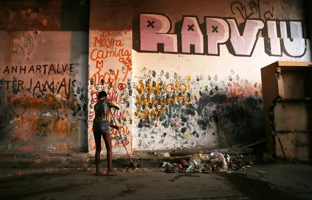 A woman sweeps outside an occupied building in the Mangueira “favela” community on August 9, 2016 in Rio de Janeiro, Brazil. (Photo by Mario Tama/Getty Images,)