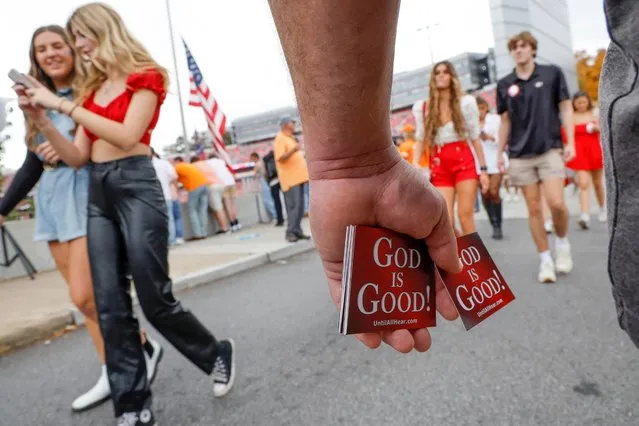 A Christian evangelist hands out cards reading “God is Good!” as fans arrive for the University of Georgia football game against the University of Tennessee, ahead of the midterm elections including former Georgia football star and Republican U.S. Senate candidate Herschel Walker, in Athens, Georgia, U.S. November 5, 2022. (Photo by Jonathan Ernst/Reuters)