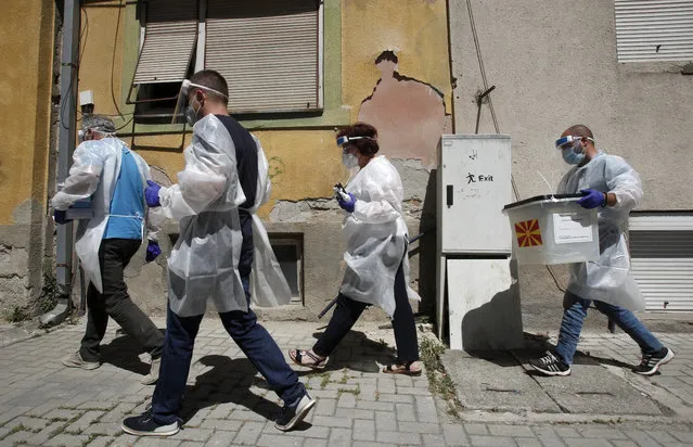Members of a special election team with a ballot box and voting material make their way visiting voters who have tested positive for COVID-19 or are in self-isolation, in Skopje, North Macedonia, Monday, July 13, 2020. North Macedonia holds its first parliamentary election under its new country name this week, with voters heading to the polls during an alarming spike of coronavirus cases in the small Balkan nation. Opinion polls in the run-up to Wednesday’s vote indicate a close race between coalitions led by the Social Democrats and the center-right opposition VMRO-DPMNE party. (Photo by Boris Grdanoski/AP Photo)