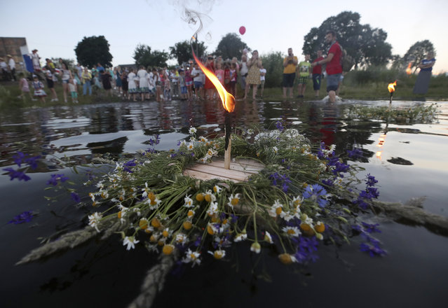 Flower wreaths with lit candles float on the water during Ivan Kupala Day celebrations held by the Pripyat River in the town of Turauin Gomel Region, Belarus on July 6, 2020. (Photo by Natalia Fedosenko/TASS)