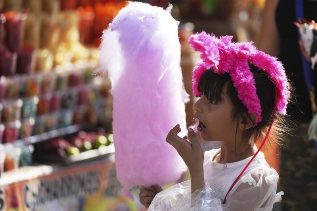 A child snacks on cotton candy at Chapultepec park in Mexico City, Saturday, March 29, 2025. (Photo by Fernando Llano/AP Photo)