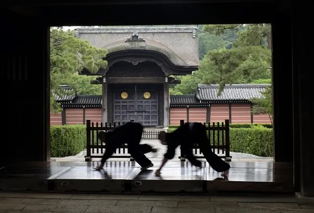 Monks polish the wooden corridor of the walkway that connects between temple buildings at Soji-ji in Yokohama, Japan, one of the largest temples of Zen Buddhism school in the country, Tuesday, July 5, 2016. (Photo by Kiichiro Sato/AP Photo)