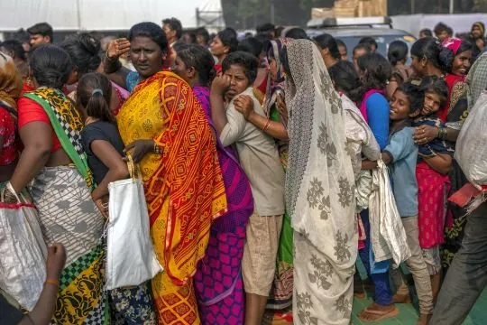 Indian women and children stand in a queue for free food distributed to mark Bhim Rao Ambedkar's death anniversary in Mumbai, India, Tuesday, December 6, 2022. Ambedkar, an untouchable, or dalit, and a prominent Indian freedom fighter, was the chief architect of the Indian Constitution, which outlawed discrimination based on caste. (Photo by Rafiq Maqbool/AP Photo)
