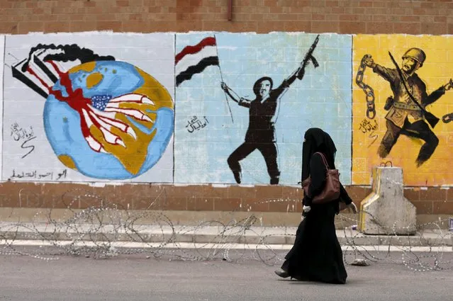 A woman walks past graffiti painted by pro-Houthi activists on the wall of the Saudi embassy in Yemen's capital Sanaa August 18, 2015. (Photo by Khaled Abdullah/Reuters