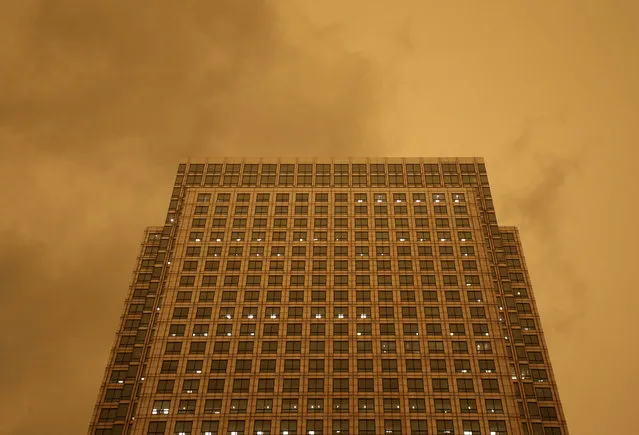 The sky turns red over buildings in Canary Wharf as dust from the Sahara carried by Storm Ophelia filters sunlight over London, Britain, October 16, 2017. (Photo by Tom Jacobs/Reuters)