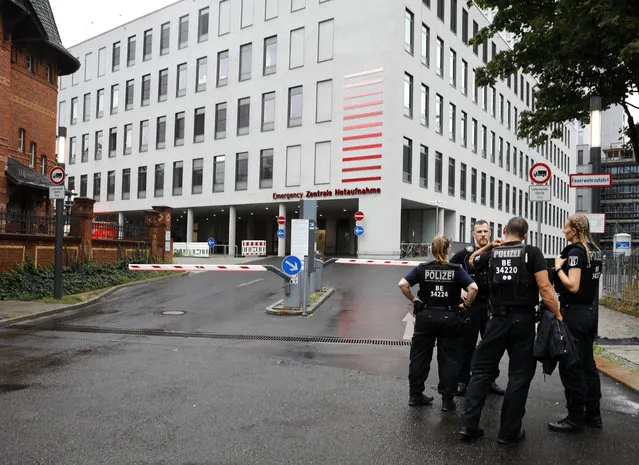 German police officers stand in front of the emergency entrance of the Charite hospital where Alexei Navalny is expected to arrive in Berlin, Germany, Saturday, August 22, 2020. The dissident who is in a coma after a suspected poisoning has been transferred from the Siberian city of Omsk. Navalny is flown to Germany to receive treatment. (Photo by Markus Schreiber/AP Photo)