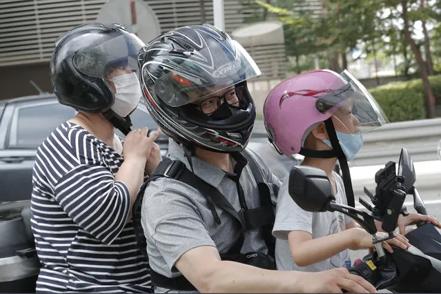 Family members wearing face masks leave after taking the COVID-19 test at a makeshift clinic in Seoul, South Korea, Thursday, August 20, 2020. (Photo by Ahn Young-joon/AP Photo)
