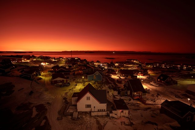 The sun sets in Ilulissat, Greenland, Tuesday, February 18, 2025. (Photo by Emilio Morenatti/AP Photo)