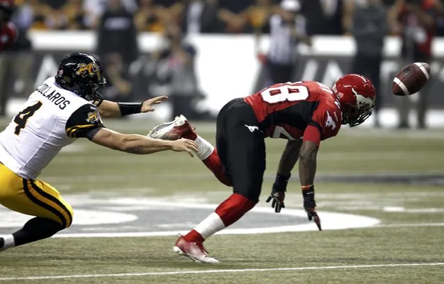 Hamilton Tiger Cats' quarterback Zach Collaros (L) and Calgary Stampeders' Brandon Smith scramble for a loose ball during the first half of the CFL's 102nd Grey Cup football championship in Vancouver, British Columbia, November 30, 2014. (Photo by Andy Clark/Reuters)