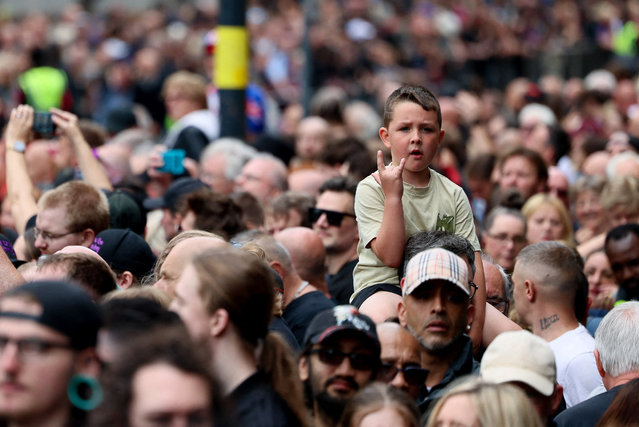 A child gestures as people gather for the funeral cortege of Ozzy Osbourne, the former Black Sabbath frontman, in Birmingham, Britain, on July 30, 2025. (Photo by Jack Taylor/Reuters)