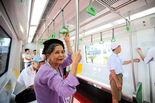 An elderly woman stands inside a model of the skytrain displayed at Giang Vo exhibition center in Hanoi, Vietnam, 30 October 2015. The model is opened to public for people to visit and give feedback before the skytrains are completed in the future. (Photo by Luong Thai Linh/EPA)