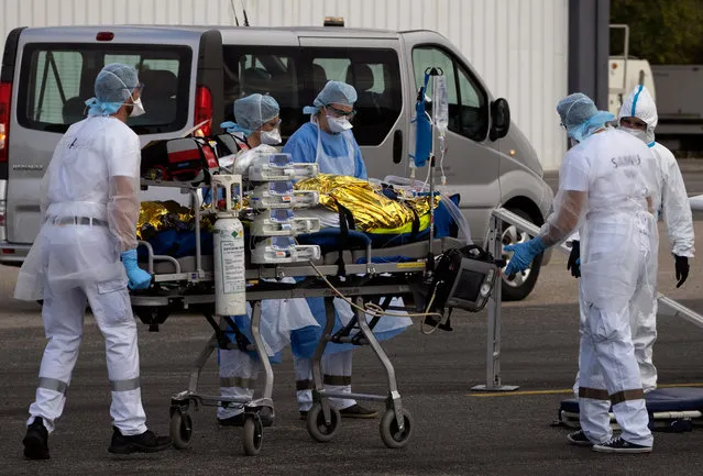 Hospital medical staff load patients with Covid-19 disease in a plane to be evacuated at Avignon's airport, France, 04 November 2020. France is in the midst of a second wave of the COVID-19 coronavirus pandemic recording 3,900 patients now hospitalized in intensive care units (ICU). (Photo by Guillaume Horcajuelo/EPA/EFE)
