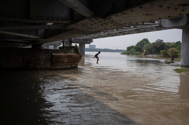 A boy jumps in the overflowing river Yamuna after heavy monsoon rains in New Delhi, India, on August 28, 2025. (Photo by Adnan Abidi/Reuters)