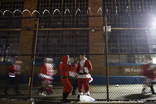 People in Santa Claus outfits attend an after-party for the “Running of the Santas” behind a barbed wire fence at the Electric Factory in Philadelphia, Pennsylvania December 13, 2014. (Photo by Mark Makela/Reuters)