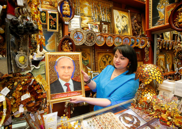 A vendor shows a portrait of the Russian President Vladimir Putin decorated with amber at a souvenir shop at Khrabrovo International Airport outside Kaliningrad, the host city for the 2018 FIFA World Cup, Russia April 11, 2018. (Photo by Sergei Karpukhin/Reuters)