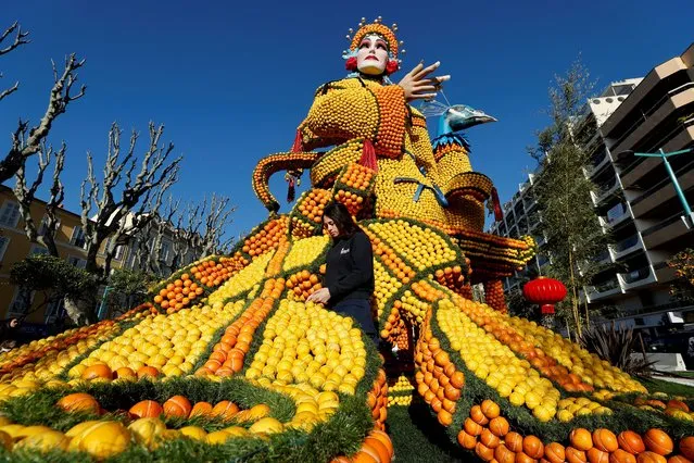 A worker puts the final touches on a sculpture made with lemons and oranges named “The Beijing Opera” during the 88th Lemon festival around the theme “Operas and dances” in Menton, France, February 10, 2022. (Photo by Eric Gaillard/Reuters)