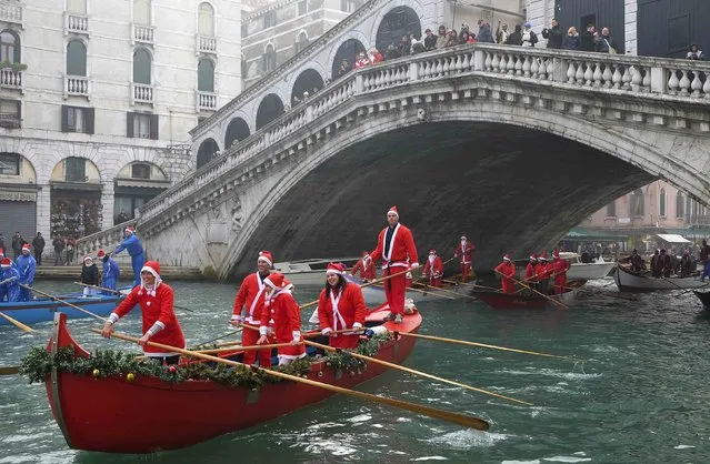 People dressed as Santa Claus ride their gondolas past the Rialto bridge in Venice December 21, 2014. (Photo by Manuel Silvestri/Reuters)
