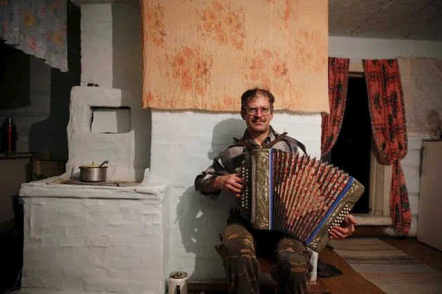 Sergei plays the accordion for Vassa, his partially deaf mother, in their house in the village of Kalach, Sverdlovsk region, Russia. October 18, 2015. (Photo by Maxim Zmeyev/Reuters)