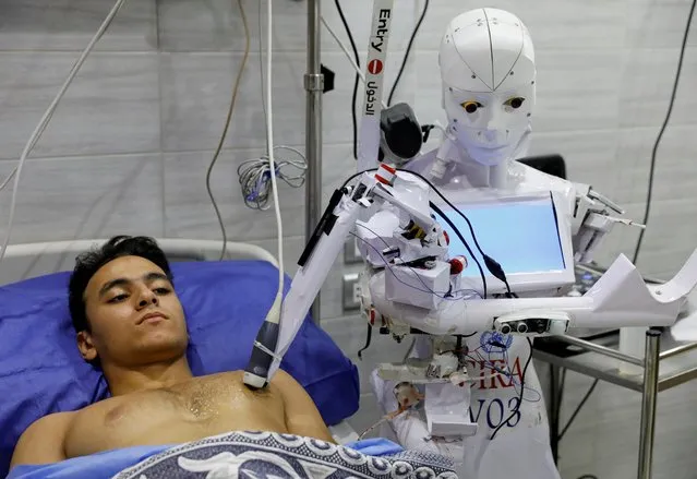 A volunteer is examined by Cira 3, a remote-controlled robot that runs tests on suspected coronavirus patients to limit human exposure to the virus, amid a second wave of infections in Tanta, Egypt, November 18, 2020. (Photo by Mohamed Abd El Ghany/Reuters)