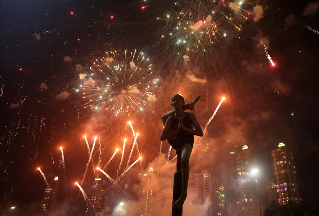 A girl performs mallakhamb, a traditional Indian sport, as fireworks illuminate the sky during Diwali, the Hindu festival of lights, in Mumbai, India, on October 22, 2025. (Photo by Francis Mascarenhas/Reuters)