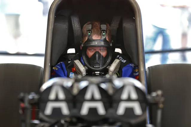 Funny Car driver Robert Hight starts his car for a pre-race check in the pits prior to his first qualifying run at the Menards NHRA Heartland Nationals drag races Friday, May 18, 2018, at Heartland Motorsports Park in Topeka, Kan. (Photo by Chris Neal/The Capital-Journal via AP Photo)