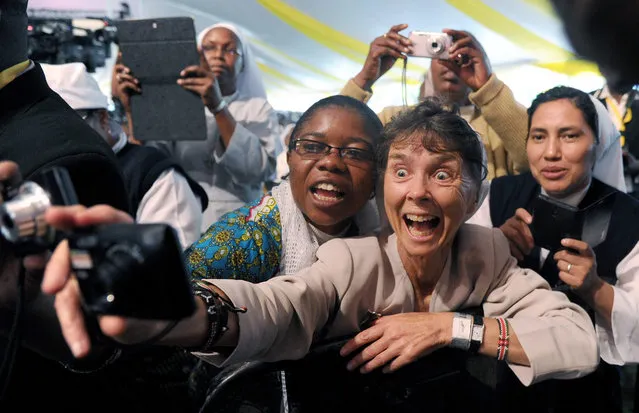 Nuns react at the arrival of Pope Francis  at the St. Mary's school to attend a meeting of clergy and religious in Nairobi, Kenya, 26 November 2015. Pope Francis is on a six days visit that will take him to Kenya, Uganda and the Repulic of Central Africa from 25 to 30 November. (Photo by Daniel Dal Zennaro/EPA)
