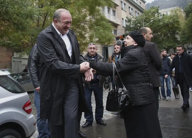 Georgian President Giorgi Margvelashvili, left, is greeted by a Georgian woman outside a polling station during a parliamentary election runoff in Tbilisi, Georgia, Sunday, October 30, 2016. The governing party in the former Soviet republic of Georgia aims to win a constitutional majority of parliament seats in the second round of national voting Sunday. (Photo by Leli Blagonravova/Presidential Press Service Handout Photo via AP Photo)