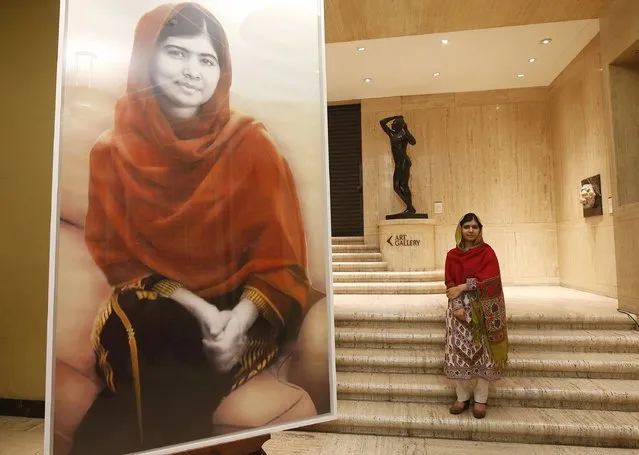 Malala Yousafzai poses with a three-meter high portrait by artist, Nasser Azam at Birmingham's Barber Institute of Fine Arts, in Birmingham, England, November 29, 2015. Pakistani teenager Yousafzai was shot in the head by the Taliban in 2012 for advocating girls' right to education. (Photo by Andrew Yates/Reuters)